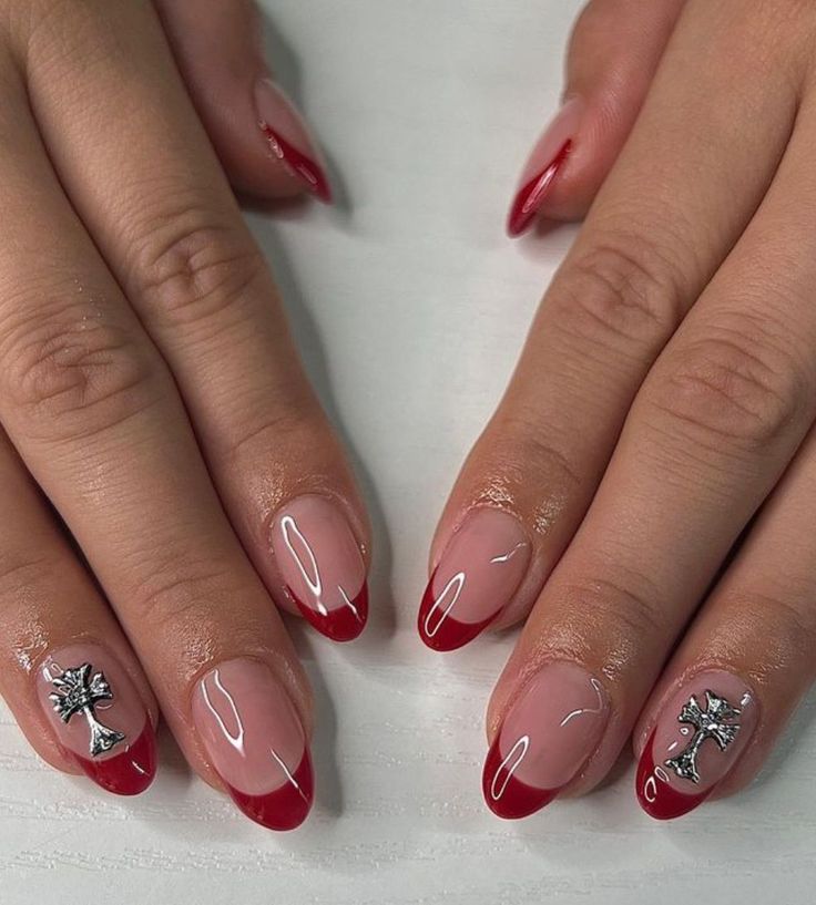 Chic French Manicure with Bold Red Tips and Metallic Embellishments.