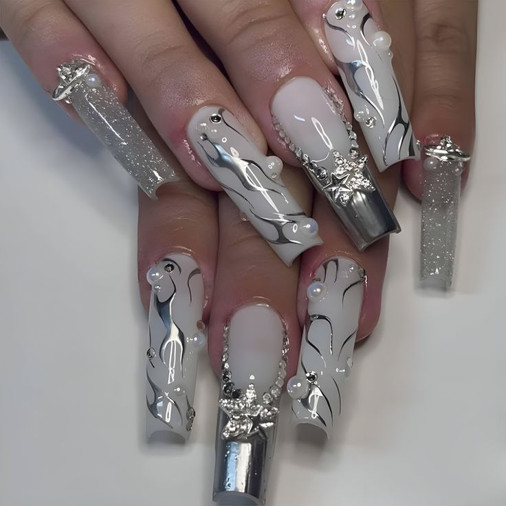 Elegant Nail Design: Glossy White and Silver with Intricate Patterns and Gemstone Accents