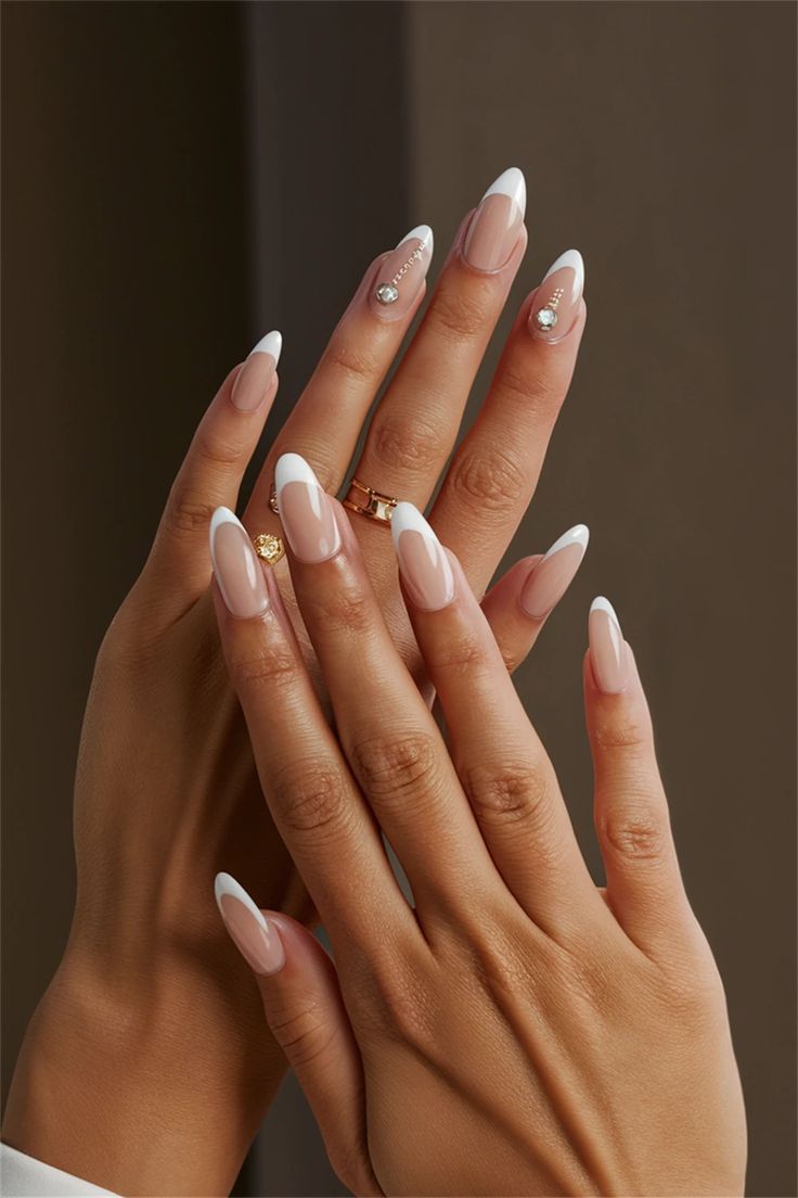 Sophisticated Almond-Shaped Nails with Glossy French Tips and Gemstone Accents.