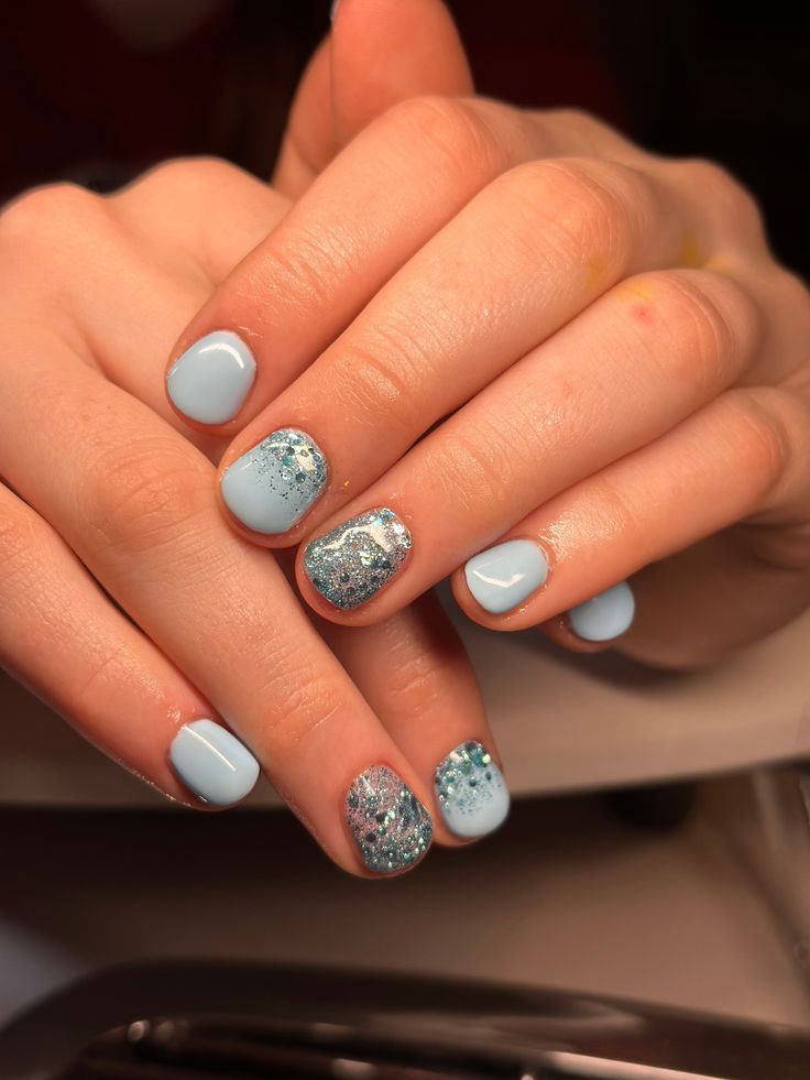 Elegant Soft Blue Nail Design with Glossy and Glittery Finishes.