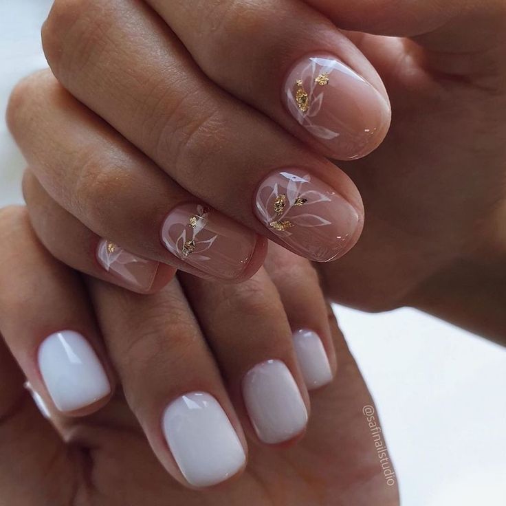 Elegant Nail Design: Soft Nude and Crisp White with Floral Patterns and Gold Leaf Accents.