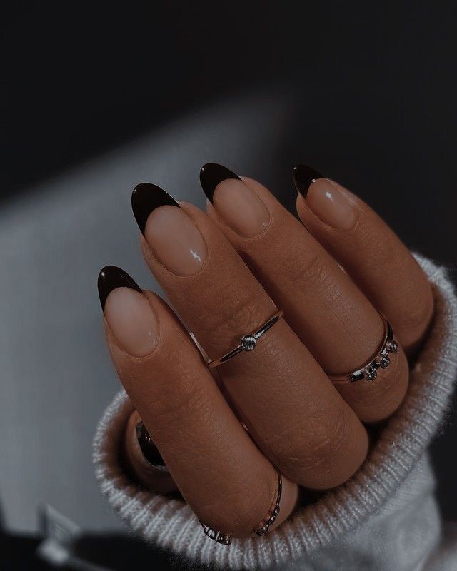 Sophisticated Nail Design: Subtle Nude Base with Striking Black Tips and Unique Shape.