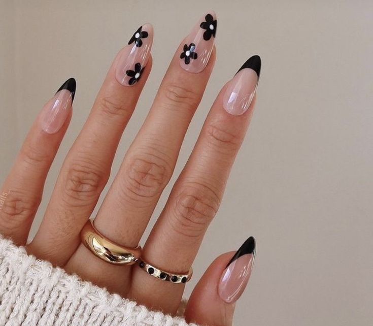 Elegant Almond-Shaped Nails with Black Tips and Floral Designs for a Playful Sophistication.