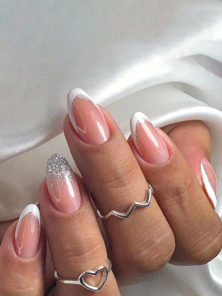 Chic French Manicure with Glitter Accent and Delicate Rings for Any Occasion.