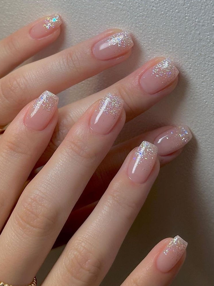 Elegant Glittery French Manicure: A Refined Blend of Nude Polish and Shimmering Tips.