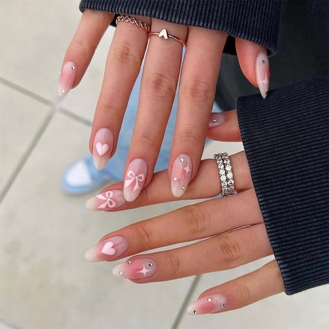 Charming Ombre Nail Design with Pink and White Shades, Heart Motifs, and Gemstone Accents.