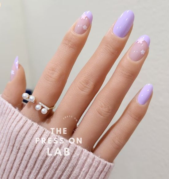 Elegant Lavender Nail Design with Floral Accents and Chic Accessories.