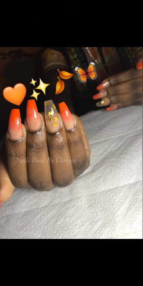 Vibrant Ombre Orange Nail Design with Sparkling Accents and Playful Motifs for a Bold Statement.