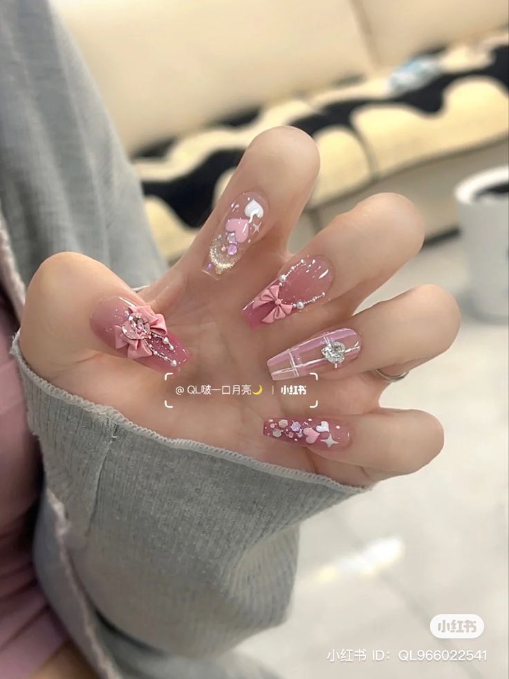 Playful Elegance: Delicate Nail Design with Soft Pinks and Intricate Embellishments.