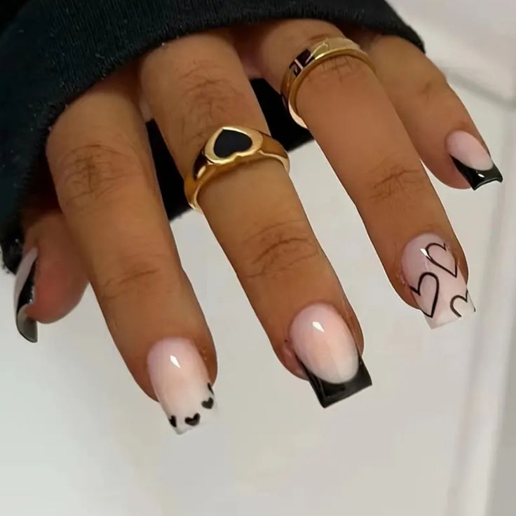 Chic Nail Design: Soft Pink & Bold Black with Heart Accents and Gold Ring Elegance