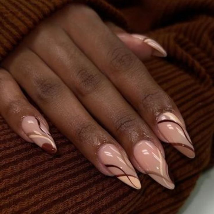 Chic Almond-Shaped Nails: Soft Nude and Light Pink with Artistic Dark Swirls.