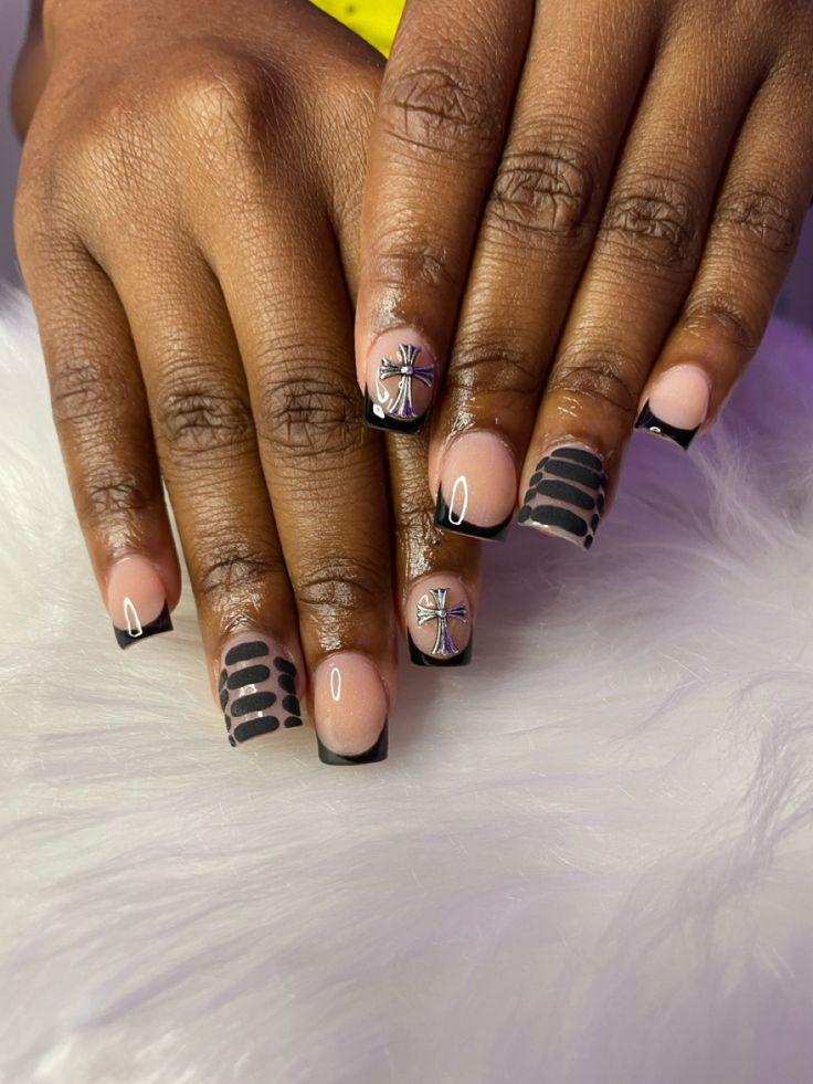 Elegant Nude and Bold Black Nail Design with Intricate Patterns and Embellishments for a Stylish Manicure.