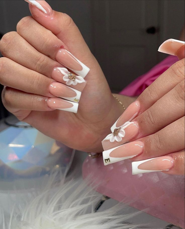 Sophisticated Nude and White Tip Nail Design with Floral Embellishments.