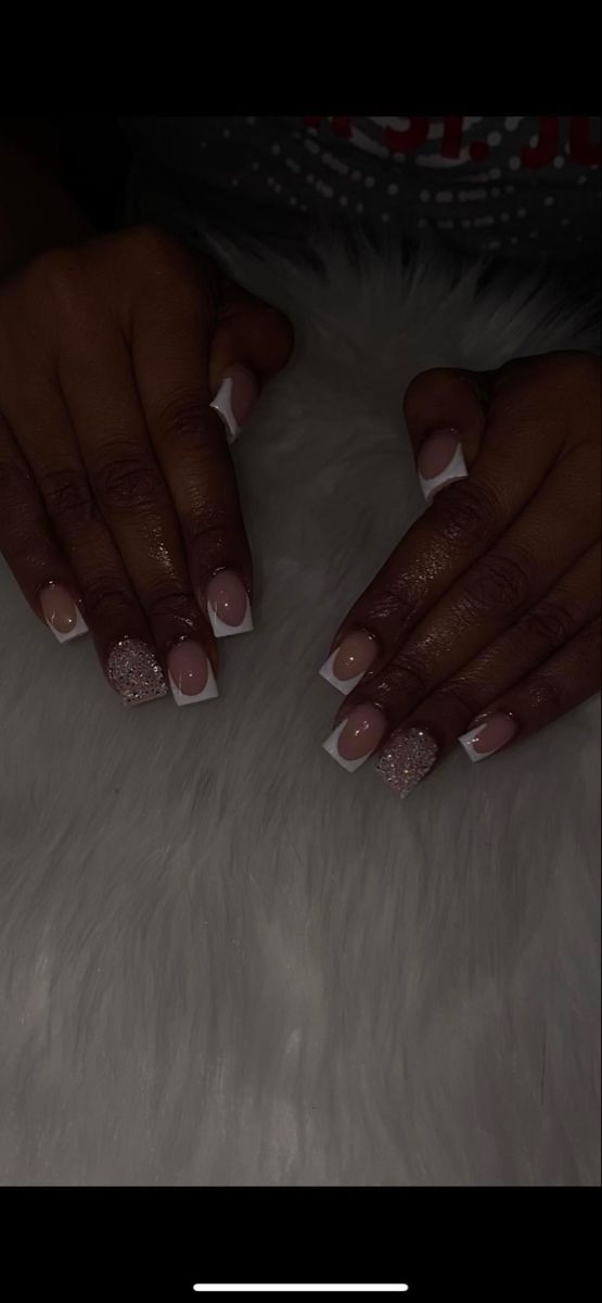 Chic Elegant Nail Design: Soft Nude Base with French Tips and Glitter Accents.