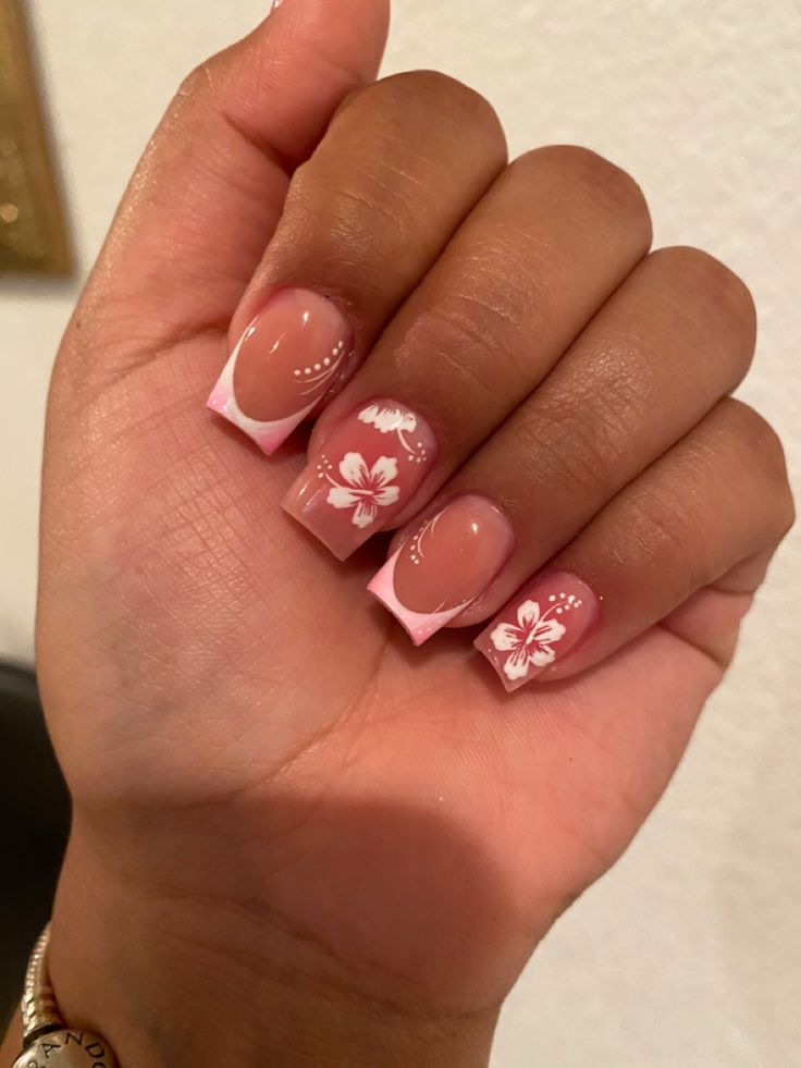 Sophisticated Soft Pink Nail Design with Floral Accents and French Tips.