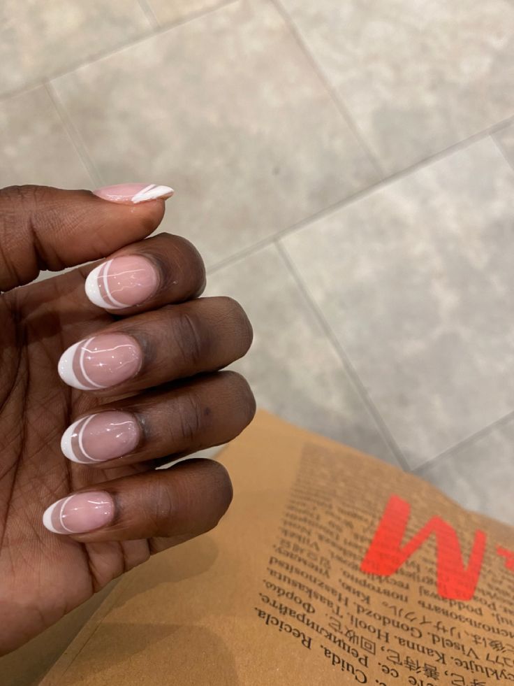 Sophisticated Soft Pink and White Tip Nail Design with Delicate Accents.