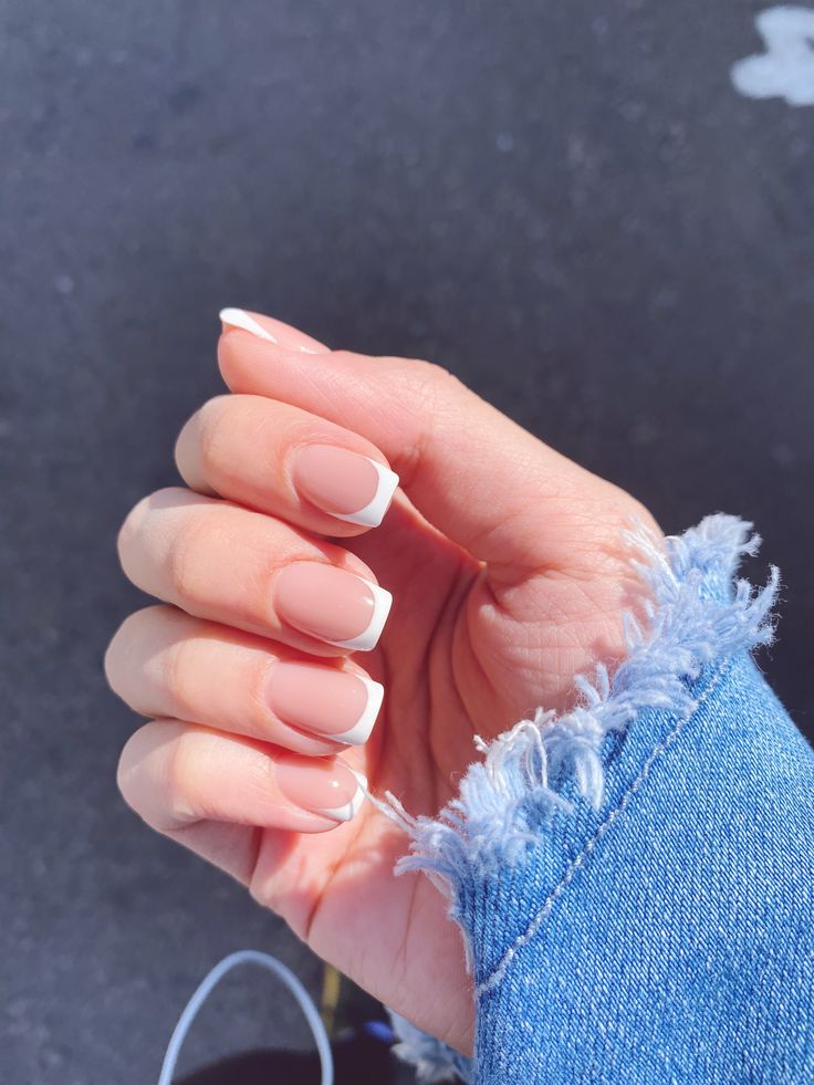 Chic French Manicure: Subtle Nude Base with Classic White Tips Perfectly Complementing Casual Denim.