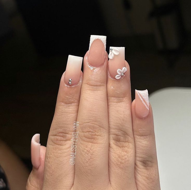 Sophisticated Nail Design with Soft Nude, White Shades, and Floral Accents.