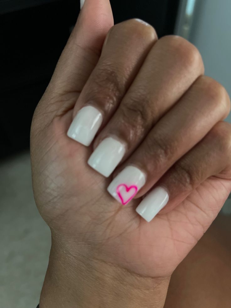 Chic Minimalist Nail Design with Soft White Base and Whimsical Pink Heart Accent.