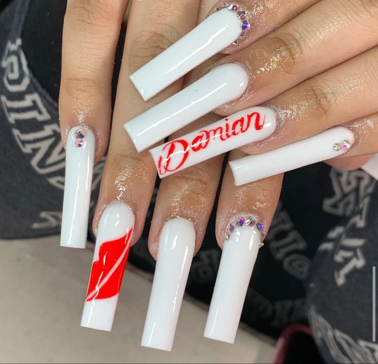 Elegant Long White Nails with Bold Red Accents and Unique Letter Artistry.