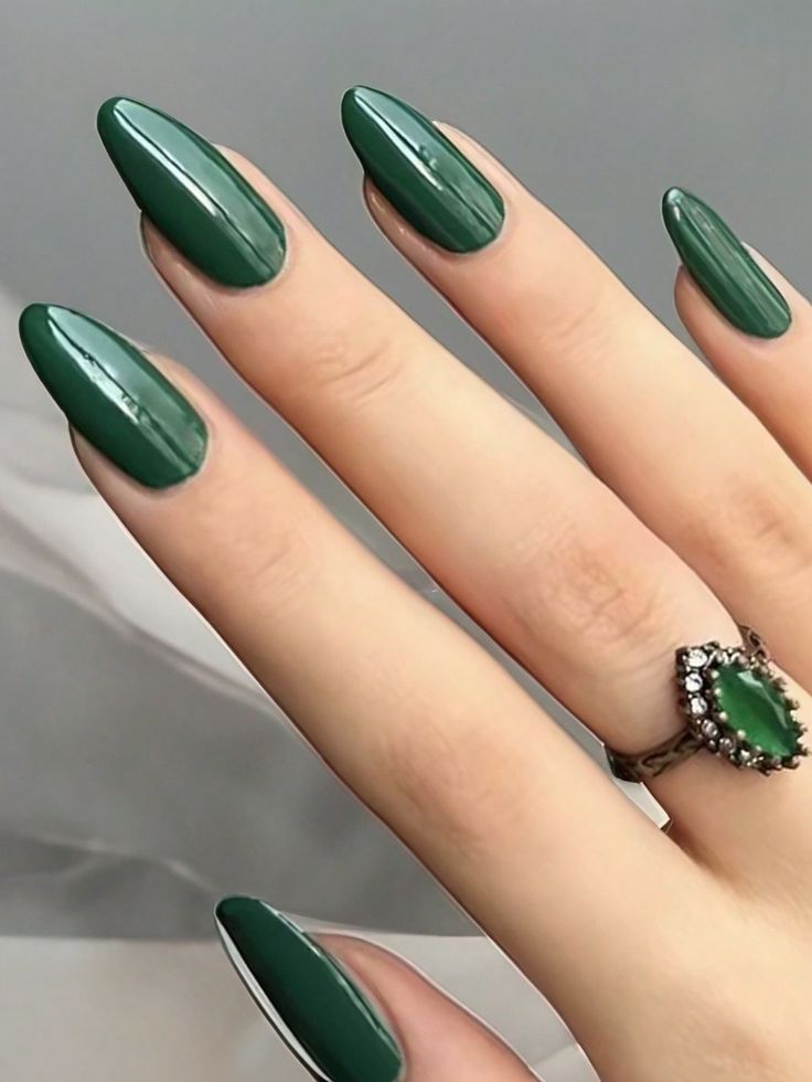 Sleek Green Almond-Shaped Nails with Glossy Finish and Vintage Ring Accent.