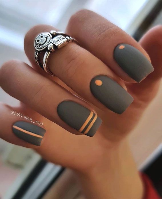 Modern Matte Gray Nails with Elegant Geometric Accents and Subtle Orange Highlights.