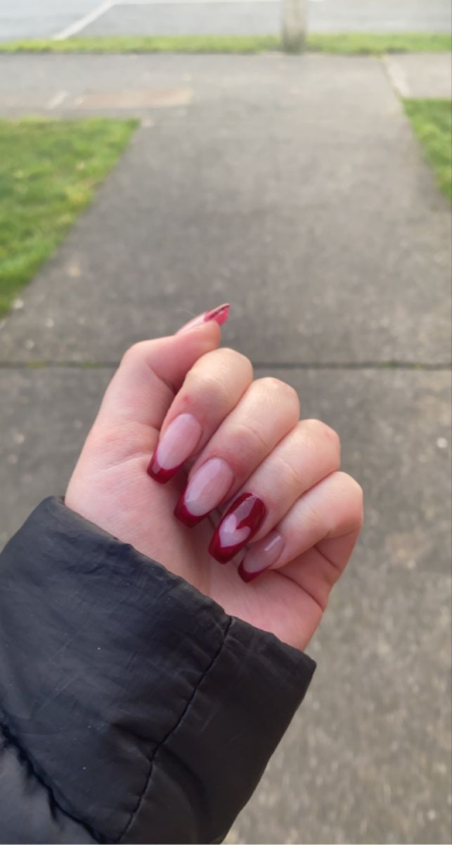 Elegant Nude and Deep Red Nail Design with Playful Heart Details