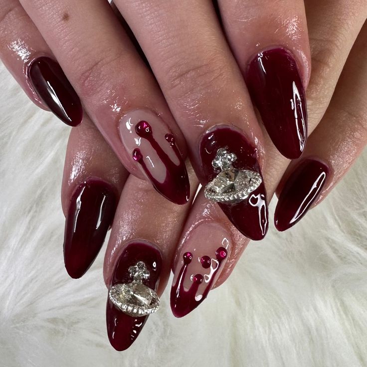 Elegant Burgundy Manicure with Glossy and Matte Finishes, Intricate Designs, and Sparkling Embellishments.