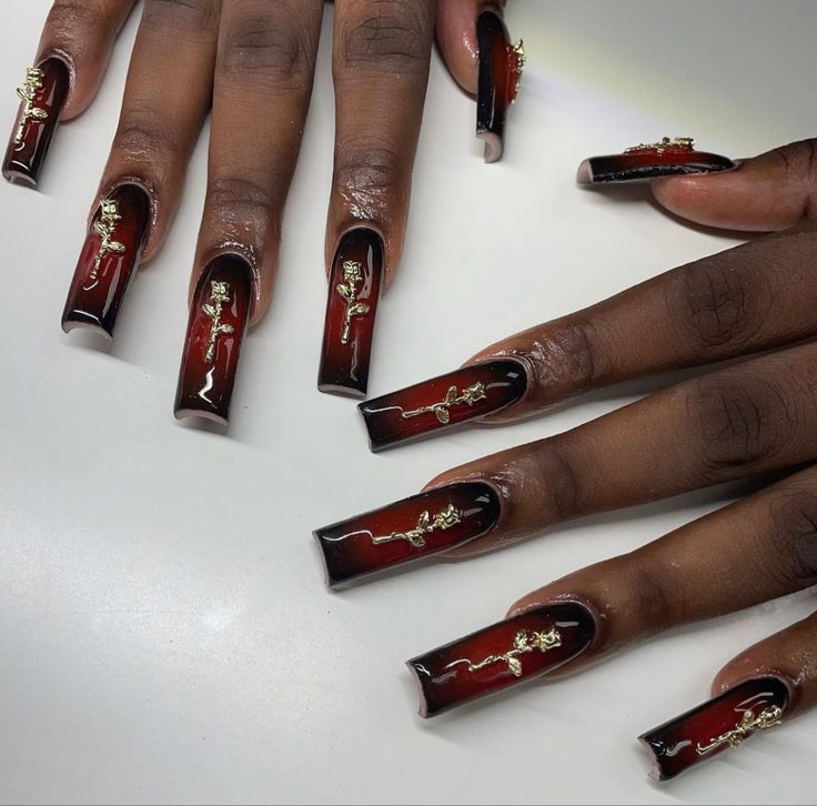 Sophisticated Long Nails with Deep Red and Black Gradient and Intricate Gold Designs.