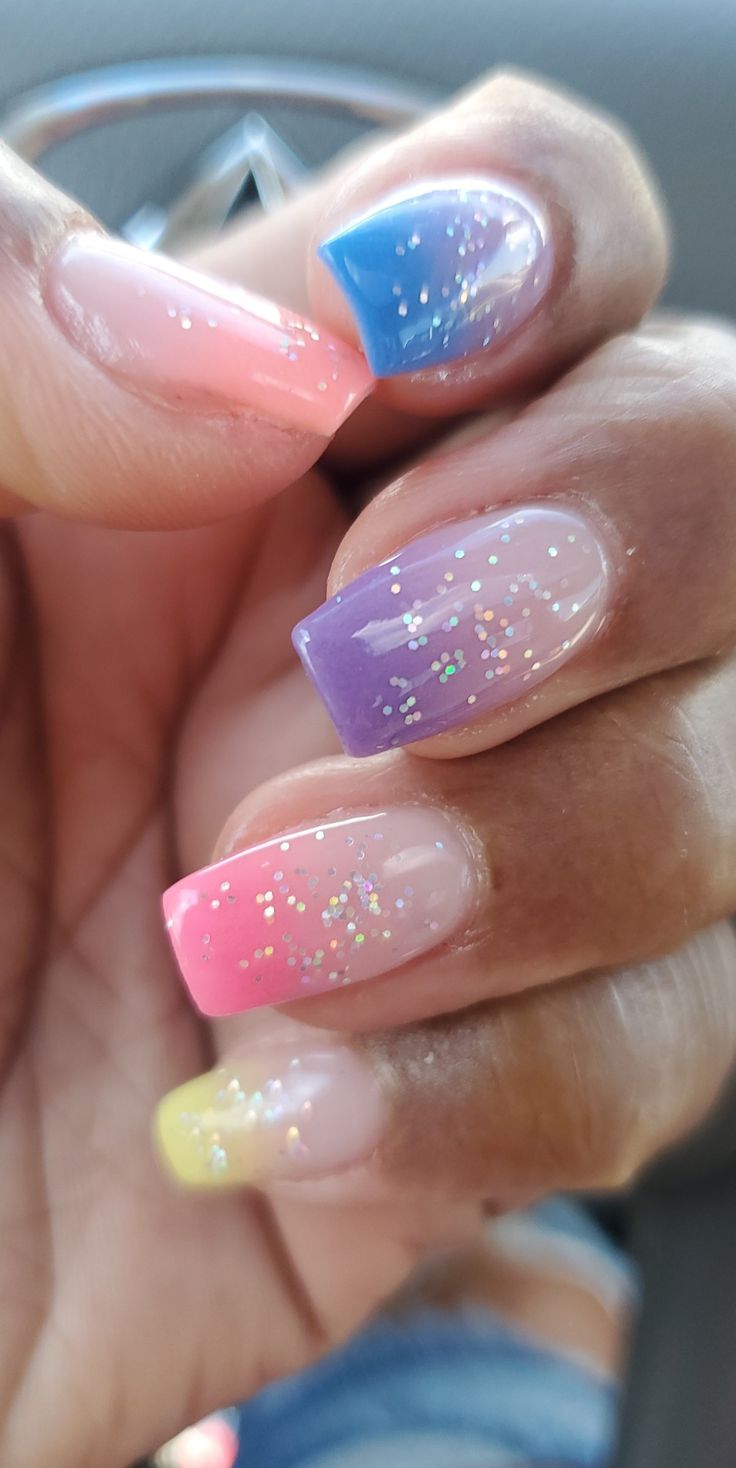 Playful Multi-Colored Gradient Nail Design with Glitter Accents.