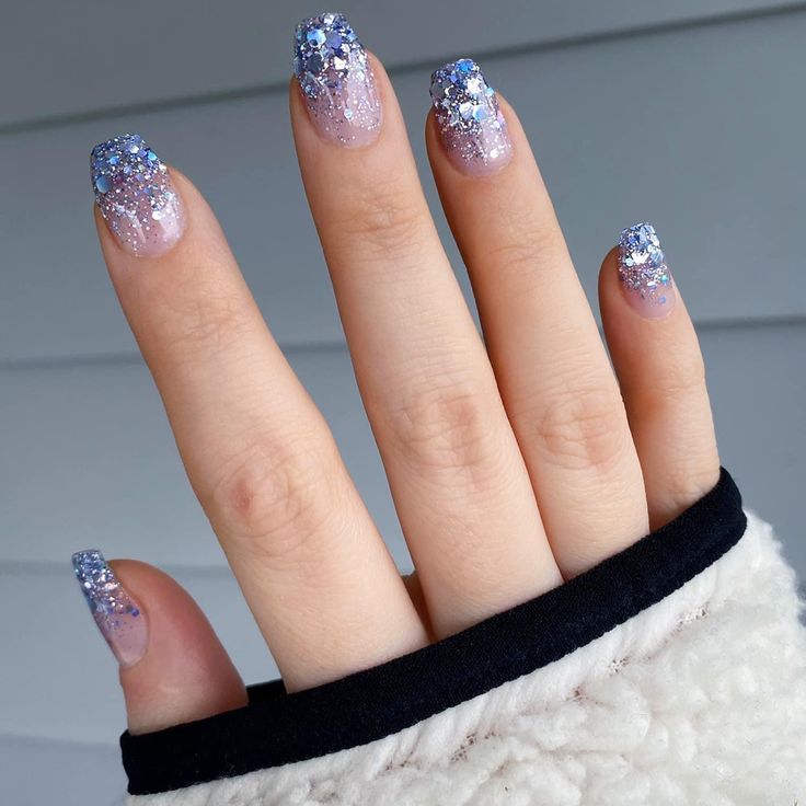 Elegant Glittery Ombre Nails with Soft Purple and Pink Gradient and Sparkling Blue-Silver Tips.