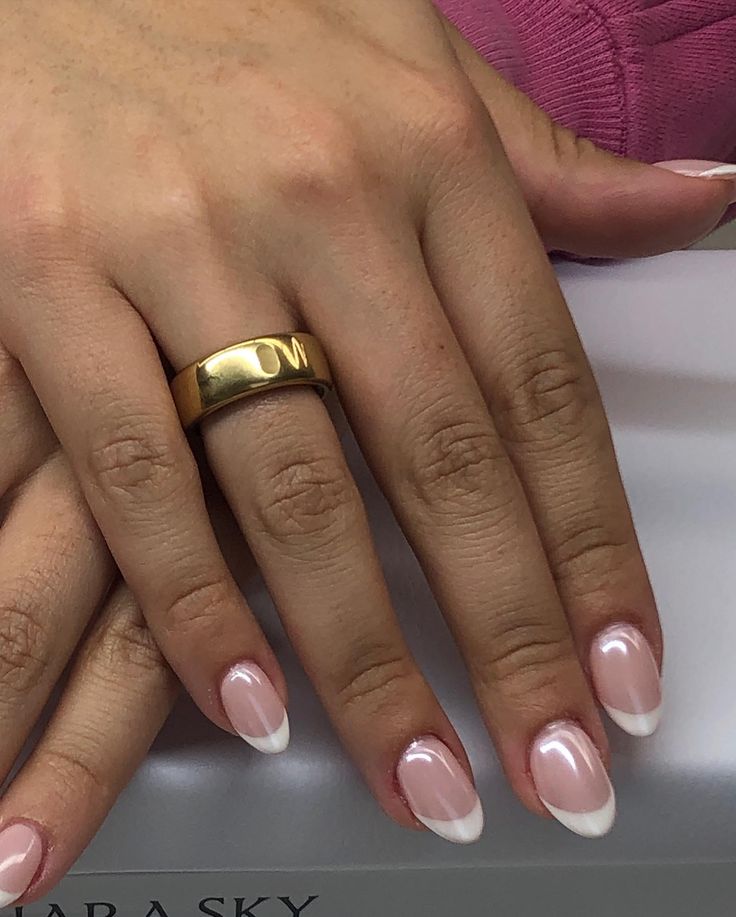 Sophisticated Soft Pink and White French Manicure Accentuated by a Bold Gold Ring