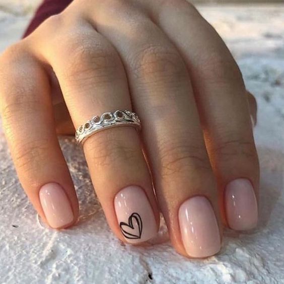 Sophisticated Nude Nail Design with Minimalist Black Heart Accent and Silver Ring Elegance