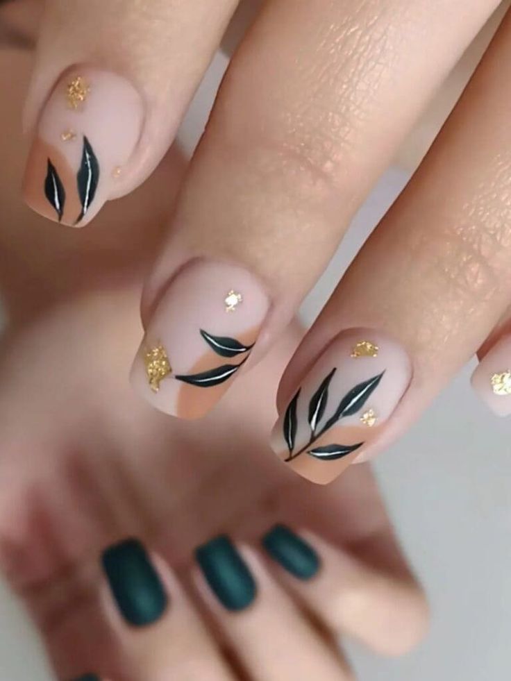 Chic Nude Nail Design with Delicate Green Leaf Patterns and Gold Accents.