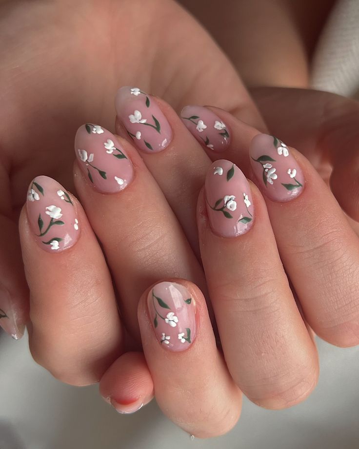 Elegant Floral Nail Design with Soft Pink Base and Intricate White Flowers.