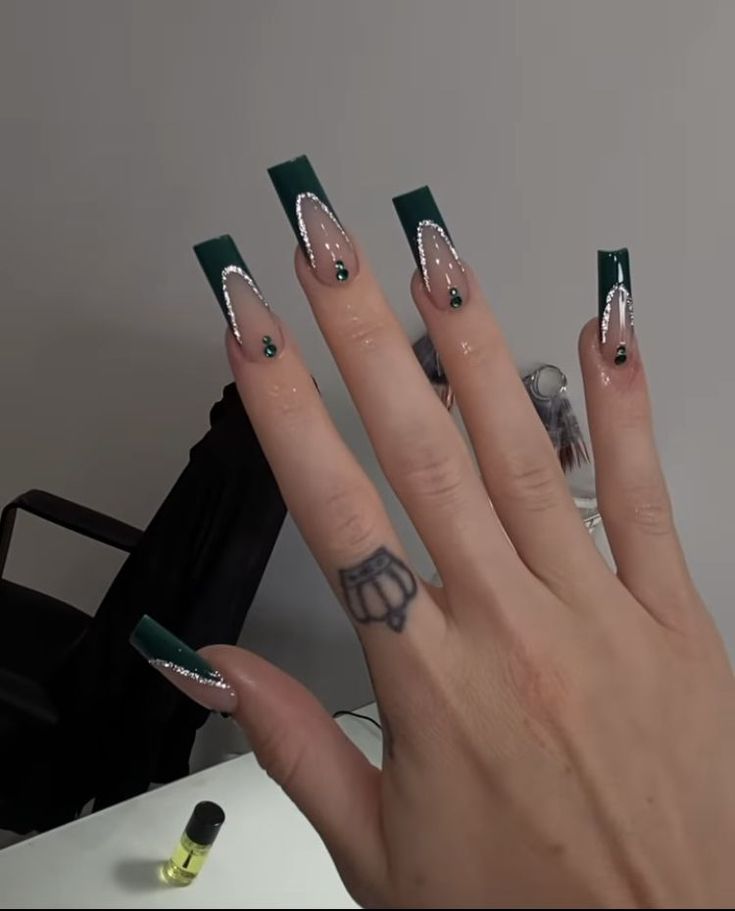 Elegant Green and Nude Long Nails with Intricate White Detailing and Sparkling Gems.