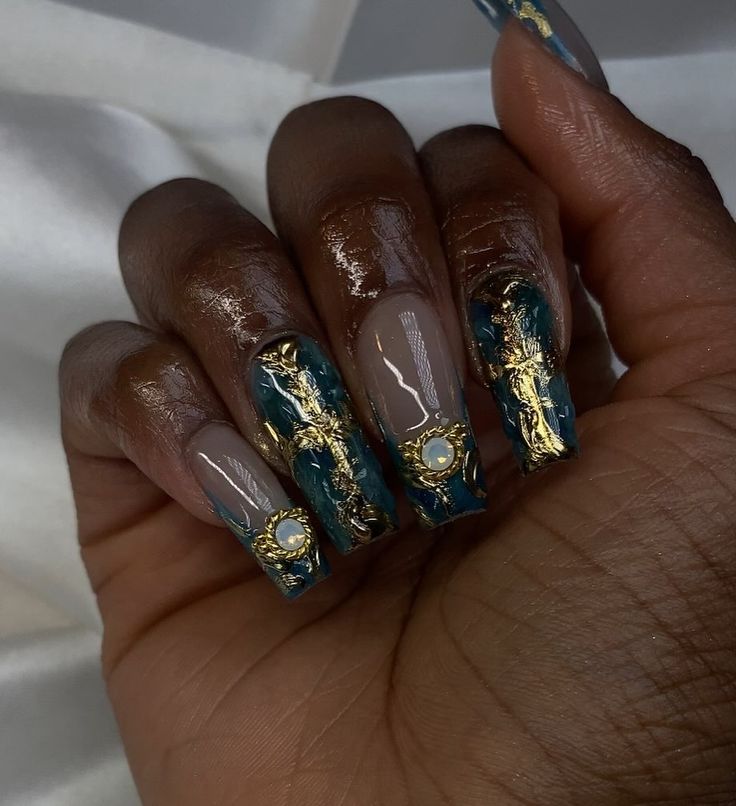 Luxurious Earthy and Teal Nail Design with Bold Gold Leaf and Gem Accents.