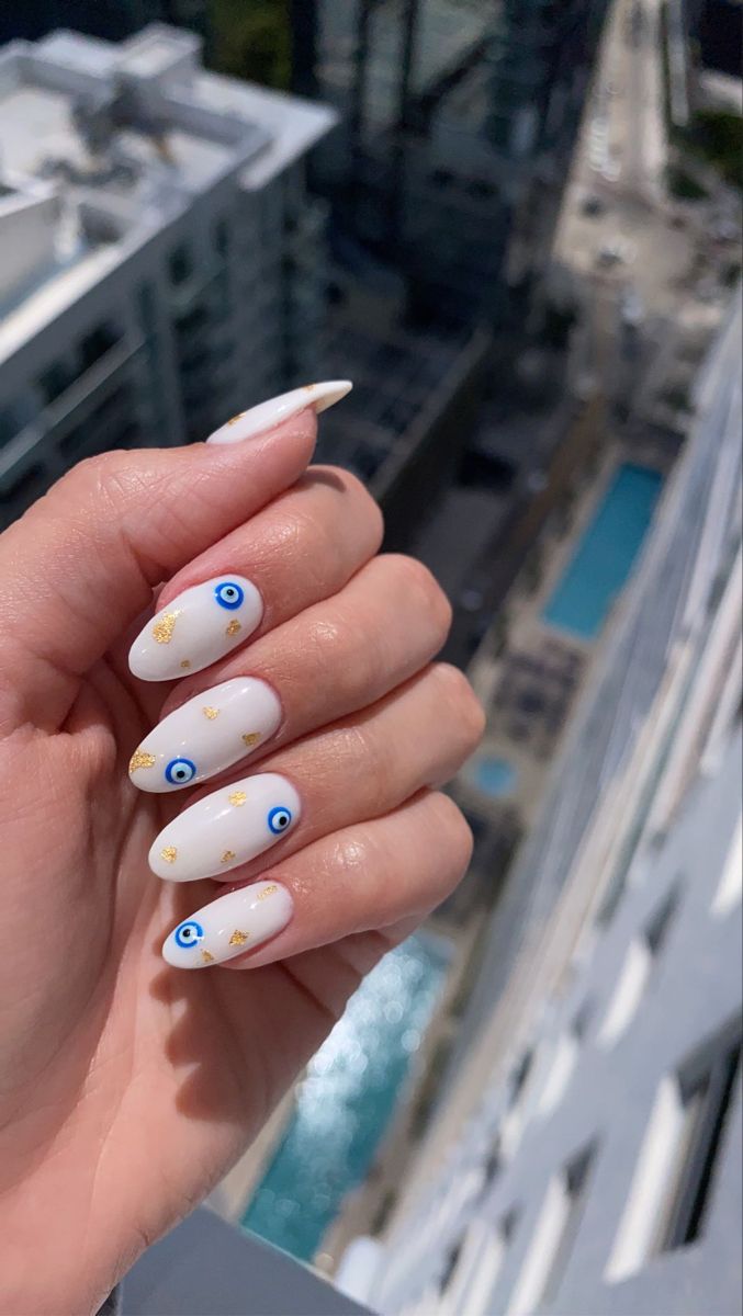 Chic Almond-Shaped Nails with Whimsical Blue Eye Motifs and Golden Accents