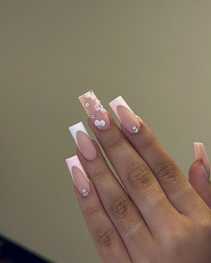 Elegant Soft Pink and White Nail Design with Glamorous Embellishments and Modern Finishes.