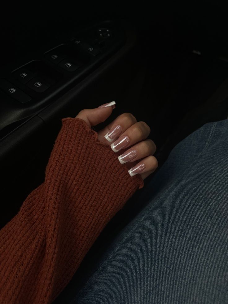 Sophisticated French Manicure with Glossy Nude Base and Chic White Tips, Perfectly Paired with a Textured Sweater.