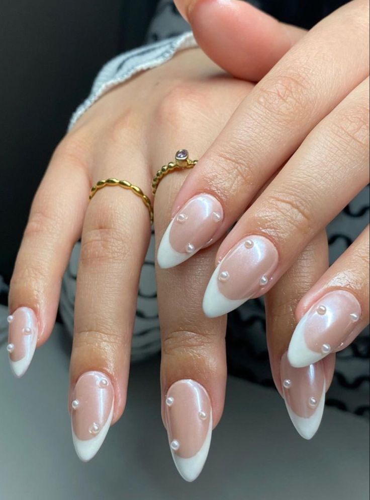 Chic Nude and French Tip Nail Design Adorned with Pearls for Elegant Versatility.