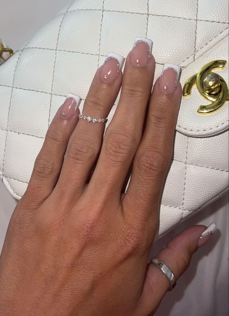 Sophisticated French Manicure with Rhinestones and Subtle Rings.