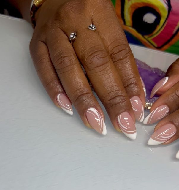 Chic Almond-Shaped Nails: Soft Nude Base with Elegant White Tips and Glossy Swirls for Sophisticated Style.