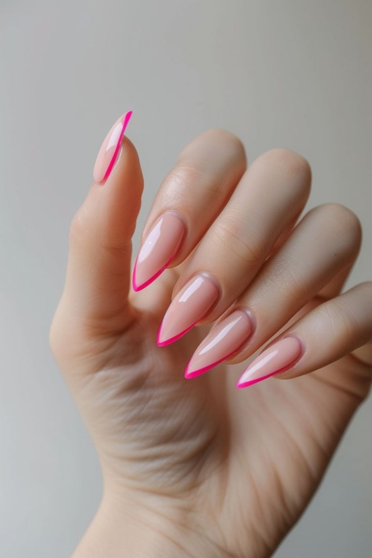 Chic Stiletto Nails: Glossy Nude Base with Vibrant Pink Tips for a Stylish Look.