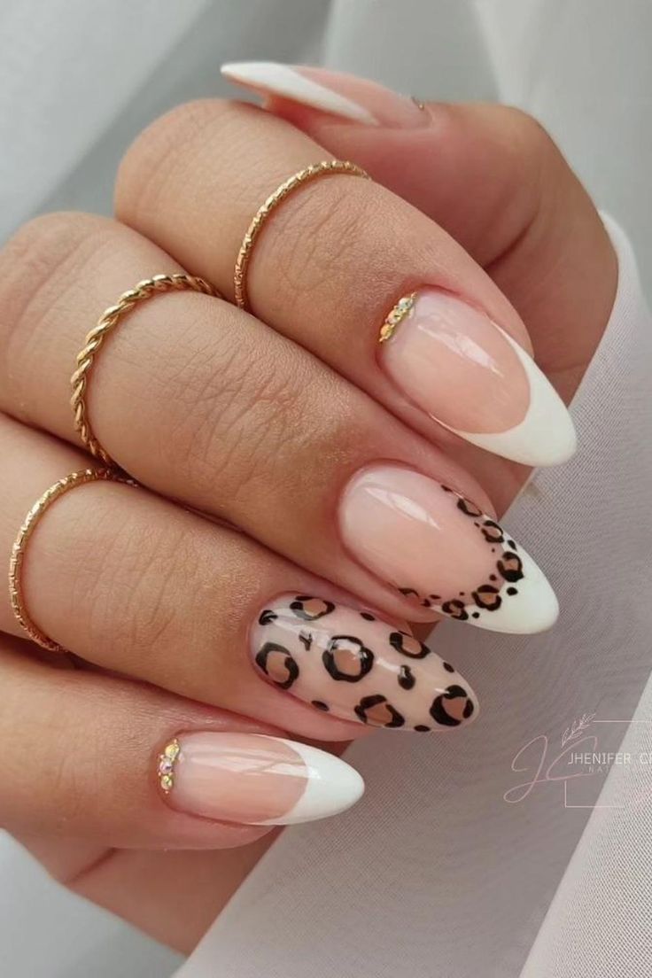 Chic French Tip Nails with Playful Leopard Accent and Sophisticated Gold Rings.