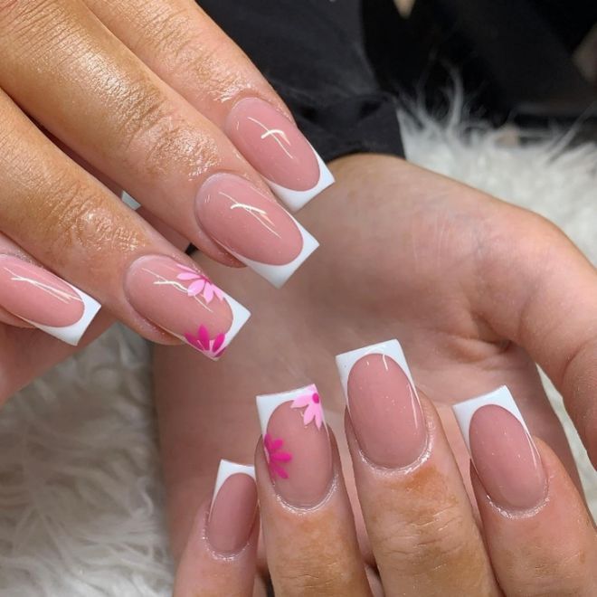 Chic Nude and White Nail Design with Delicate Pink Floral Accents.