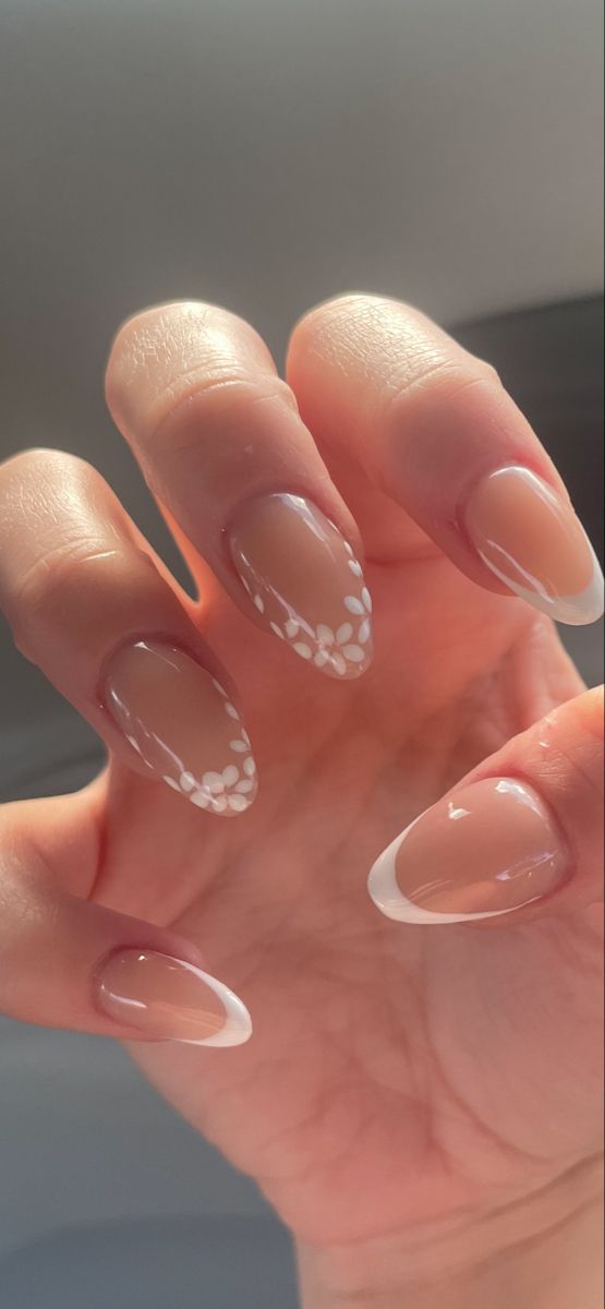 Chic Neutral and White Almond Nail Design with Floral Accents.