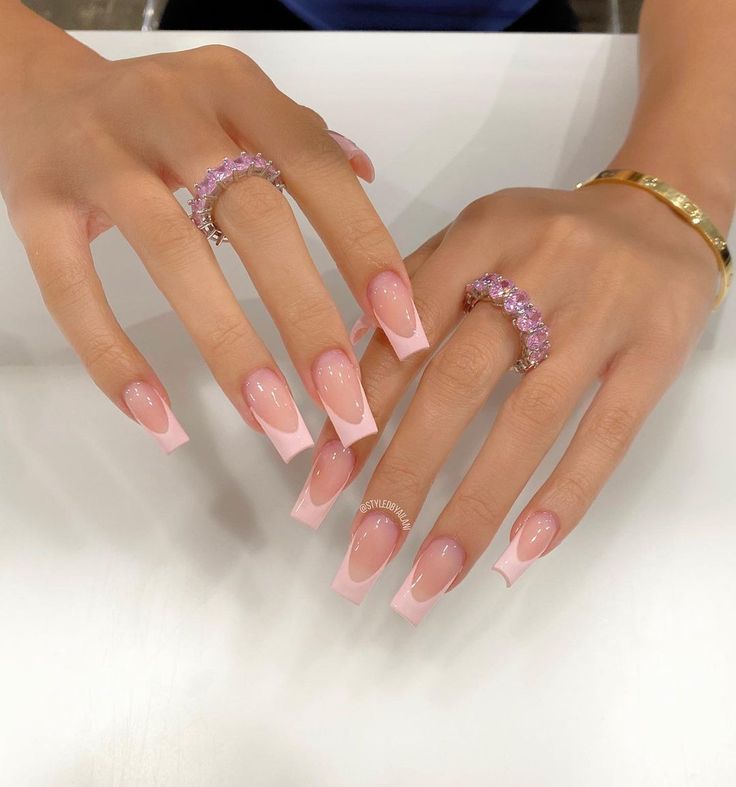 Chic Long Squared Tip Nails with Soft Pink Gradient and White Accents, Enhanced by Stunning Rings.