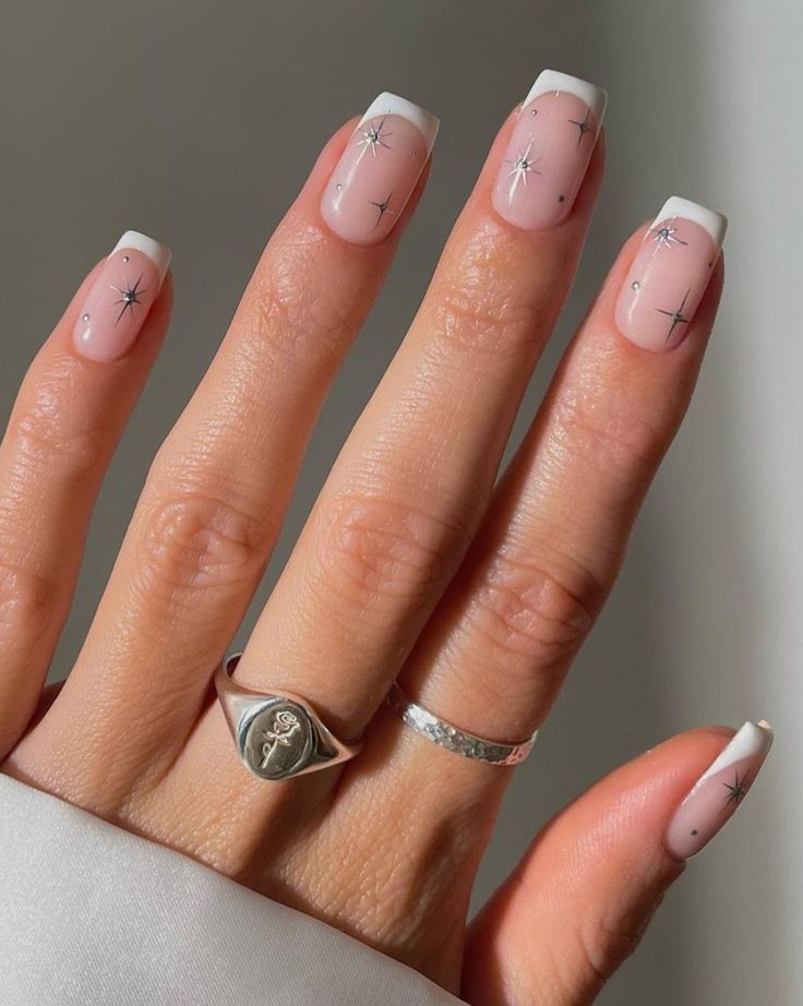 Sophisticated French Manicure with Pink Base, White Tips, and Sparkling Silver Stars.