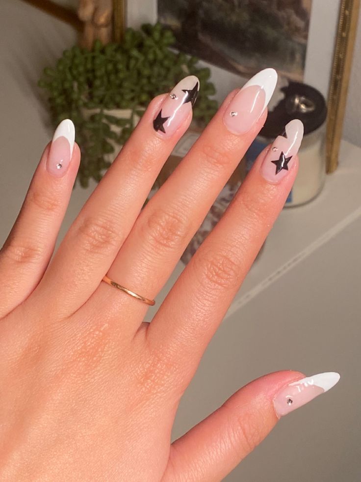 Chic and Playful Nail Design: Soft Pink and White with Glamorous Black Star Accents.